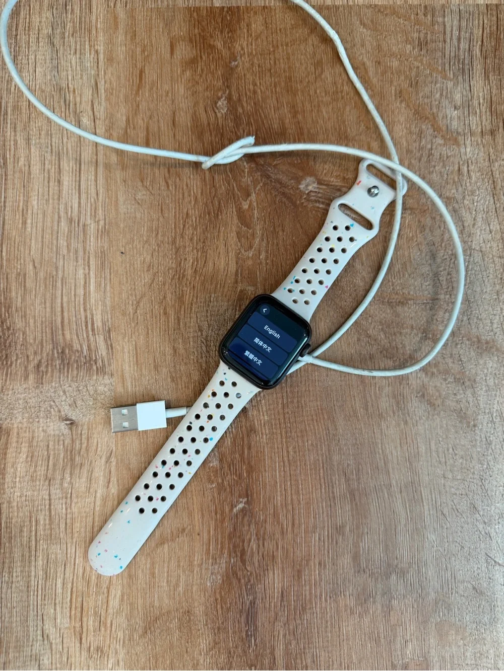 Apple Watch with White Speckled Sport Band and Charging Cable